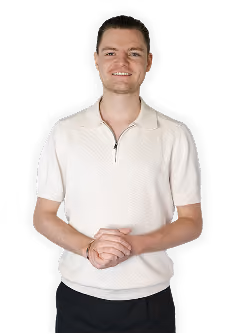 Smiling young man with short hair wearing a light-colored short-sleeve polo shirt and dark pants, standing with hands clasped in front against a black background.